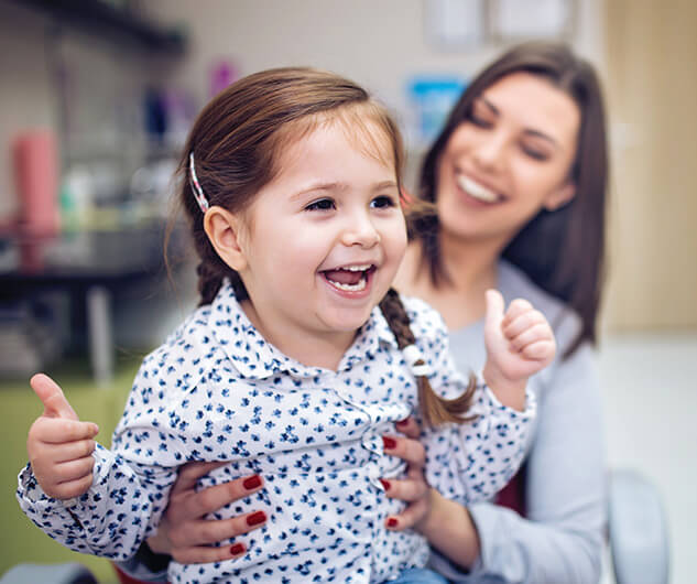 mother holding her happy, smiling daughter