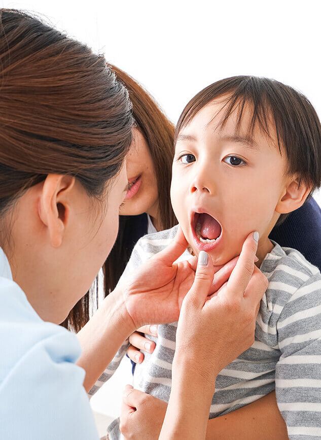 young boy having his teeth looked at by a dentist