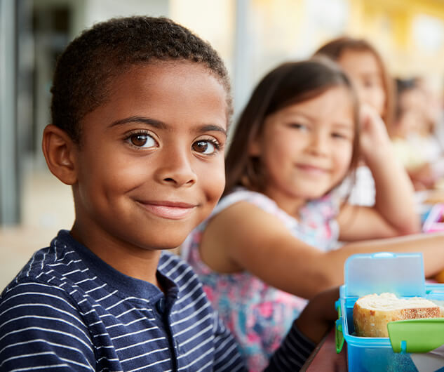 young boy and his friends eating lunch together