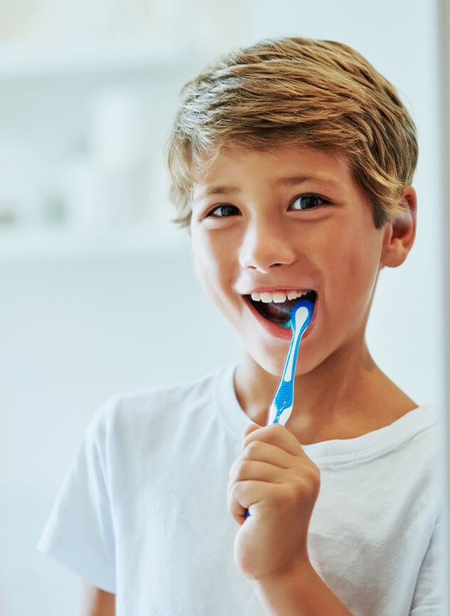 young boy brushing his teeth